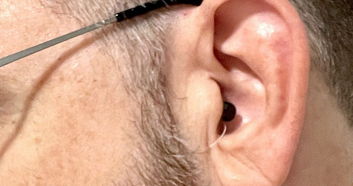 Side view of face with glasses and close up of ear with Eargo 5 inserted. 