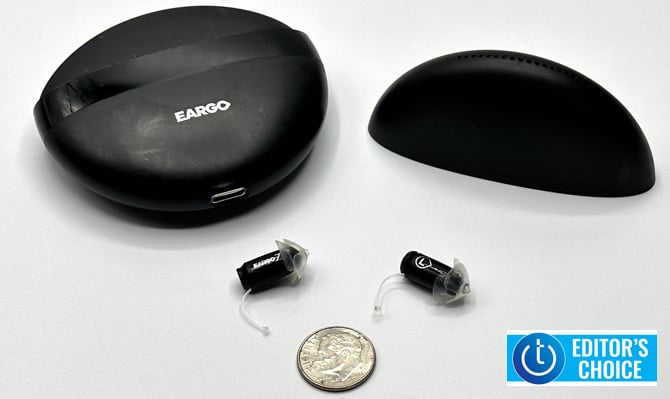 Eargo 7 shown outside of the case and a dime for scale. The Techlicious Editor's Choice award logo is in the lower right corner.