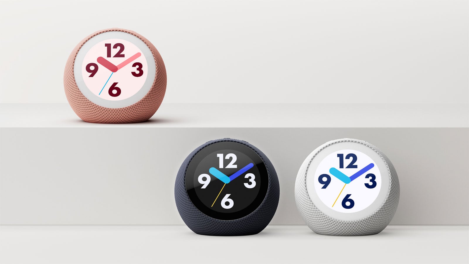 Three spherical Echo smart speakers in pink, dark blue, and white, each displaying a colorful analog clock face.
