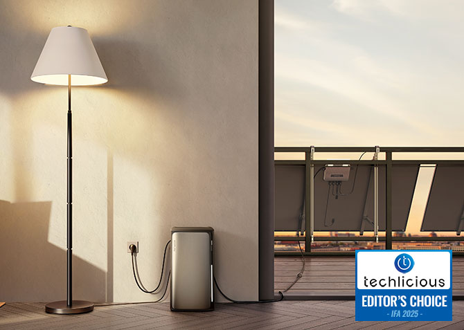  EcoFlow STREAM Series Ultra with a lamp plugged in and a solar panel plugged into the STREAM microinverter on a balcony.. The Techlicious Editor's Choice Award logo is in the lower right. 