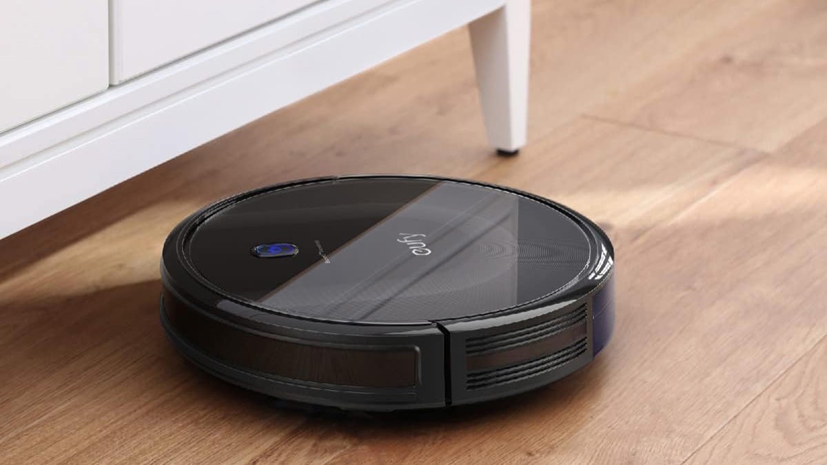 Narwal Flow 2 robot vacuum and mop positioned in front of its docking station on a purple display table.