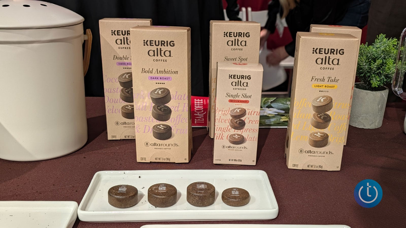 Boxes of Keurig Alta coffee and espresso in different roasts, with round AltaRounds pressed coffee pods displayed on a white tray.
