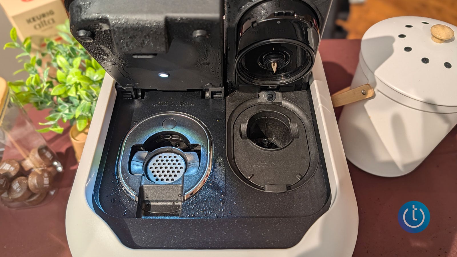 Close-up of the Keurig Alta coffee machine with its top lid open, revealing separate brewing compartments for coffee and espresso pods.