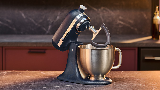 KitchenAid Artsan Plus tilted open showing the new double flex edge beater with silicone edges .