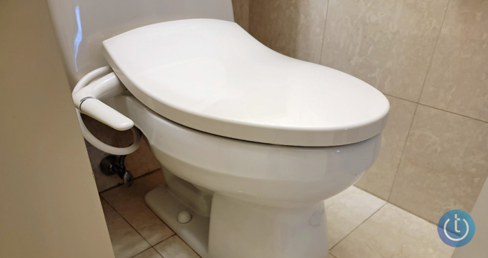 Kohler Puretide bidet installed on toilet see from the top down on a side angle.