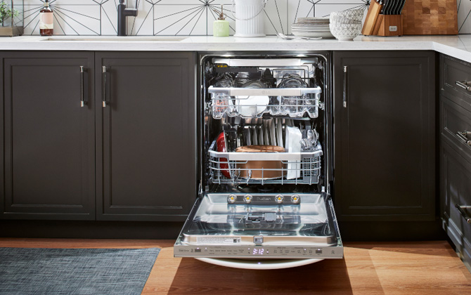 LG Wi-Fi Enabled Top Control Dishwasher with QuadWash Pro and Dynamic Heat Dry shown open and installed in a kitchen with dark brown cabinets.