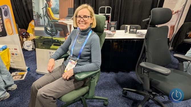 A woman sitting in the LiberNovo chair which is mechanized to promote good posture and support your body