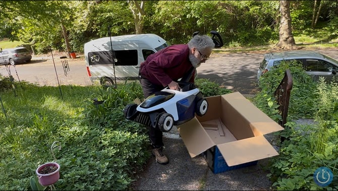 John Siemiarowski lifts the Litheli EASYSURGE 18.5-inch lawn mower out of its box.
