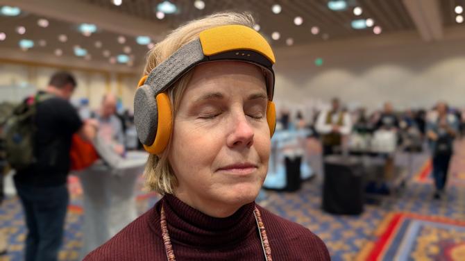 Suzanne Kantra wearing the Lumisleep headband in grey with orange ear covers