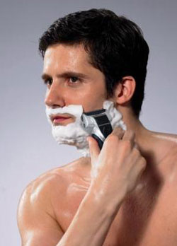 Man using electric shaver with shaving cream