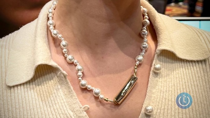 Photo of a woman wearing the nirva emotion tracker on a chain of freshwater pearls