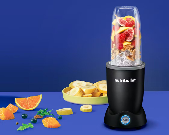 Nutribullet Pro+ with bananas, oranges, and blueberries. Ice and other fruit is in the blending cup.