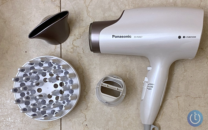 Panasonic’s Nanoe EH-NA67-W hair dryer with oscillating, diffuser, and concentrator attachment on marble background
