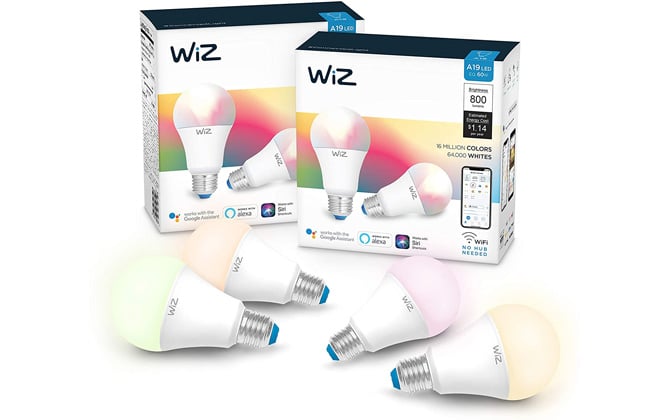 Four Philips Smart LED lights with WiZ Connected light bulbs in front of two packages of the bulbs. The bulbs are colored yellow, yellow-orange, orange, and pink