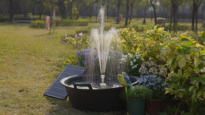 Poposoap fountain shown in birdbath with book-size solar panel next to it