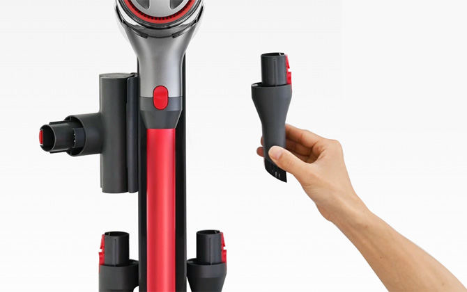 Roborock shown attached to wall mount with attachments and a hand holding the multi-surface brush tool.