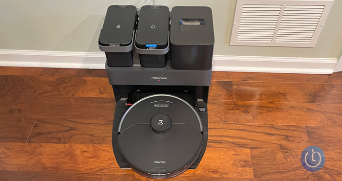 Roborock S7 MaxV Ultra seen from the top down on a wood floor against a wall.