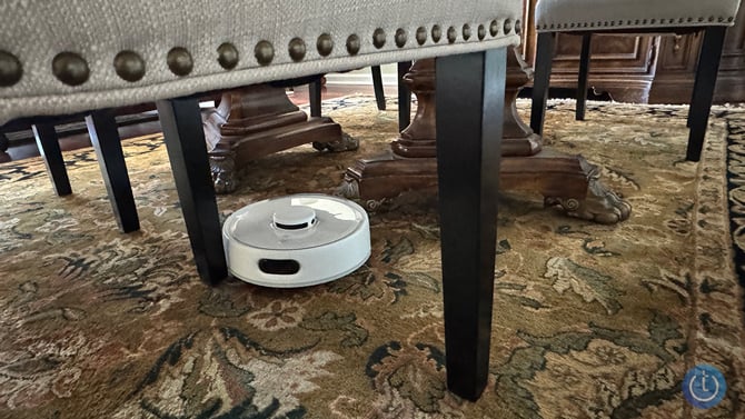 The SwitchBot K10+ Pro robot is shown maneuvering between chair legs