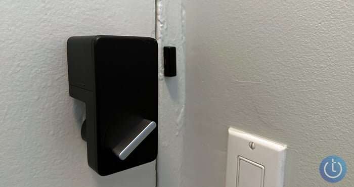 SwitchBot Lock shown mounted on door from the side with the door closed. 
