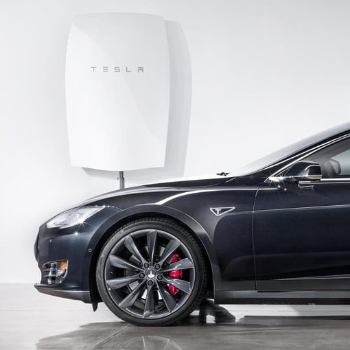 Tesla Powerwall battery mounted next to a car