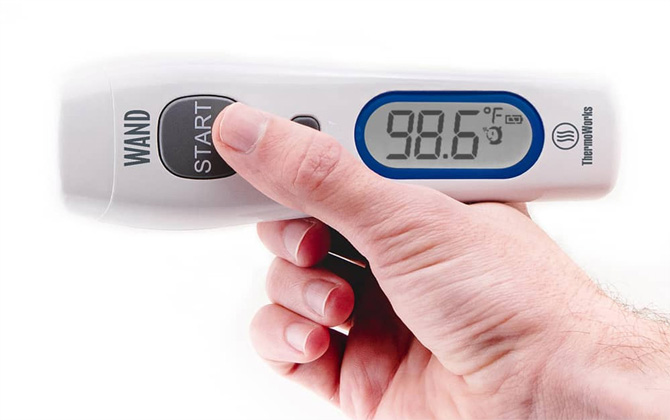 Thermoworks Wand held in hand showing a temperature of 98.6 F.