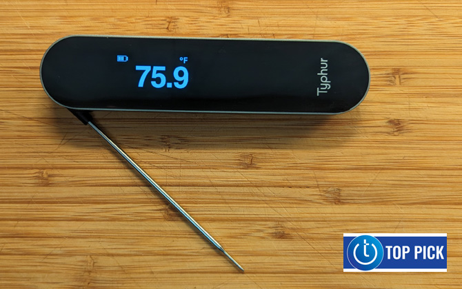 Typhur InstaProbe on wood cutting board with the probe extended and showing a termperature reading on the OLED display.