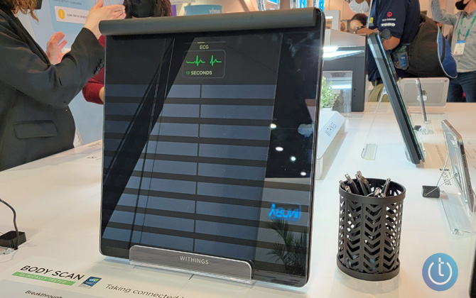 Withings Body Scan shown upright on a display table at the Withings booth at CES 2022. One the display you see ECG. 