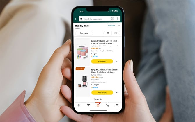 Two hands hold phone showing an Amazon Holiday wish list.