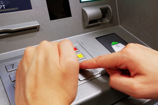 Hand shielding the entry of a PIN at an ATM