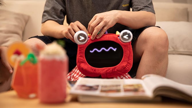 Closeup of the Ollobot OlloNi SS1 with cute red cover and anthropomorphic eyes and mouth