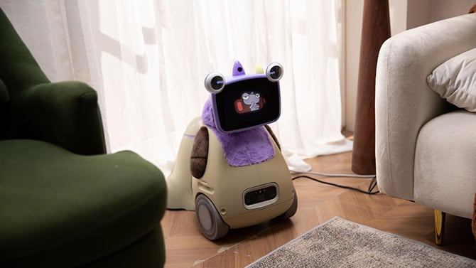Ollobot OlloNi SS1 with purple unicorn cover, shown on wheeled base in the living room with charging dock