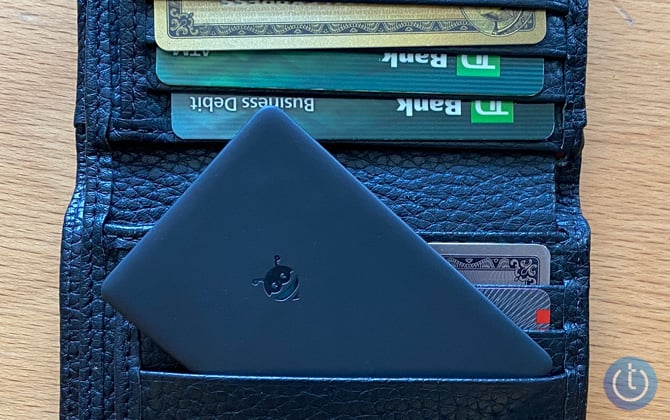 Pebblebee Card tracking sticking out of a credit card slot in a wallet with other credit cards.