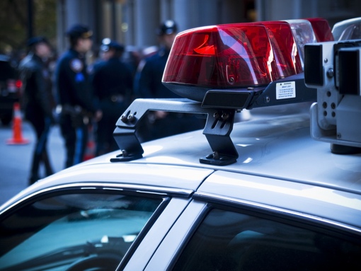 Police officers behind a police car