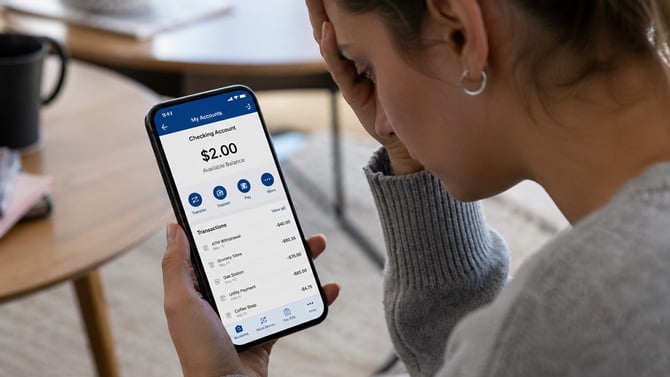 Concept image of a woman looking at a $2 bank balance.