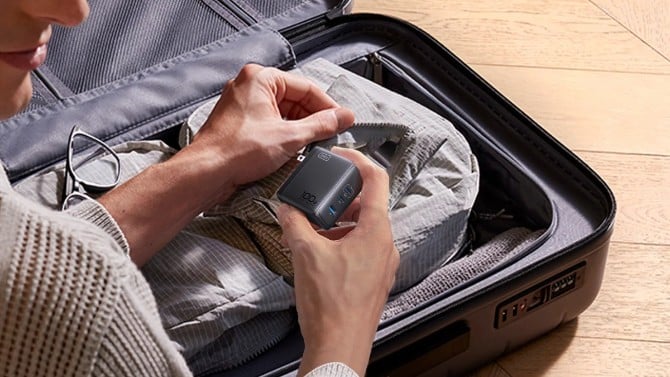 Photo of a charger being placed into a suitcase
