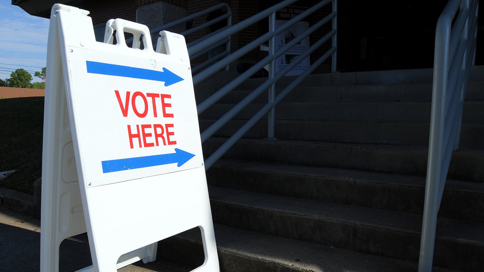 A sign says vote here with arrows point toward steps.