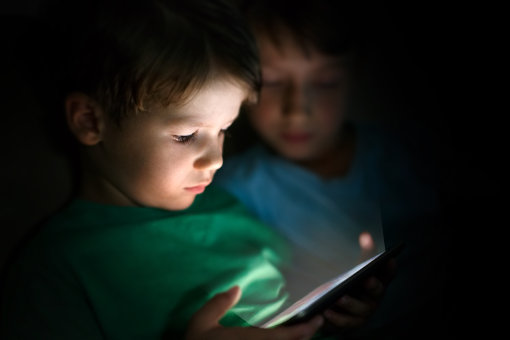 Child playing on tablet in the dark