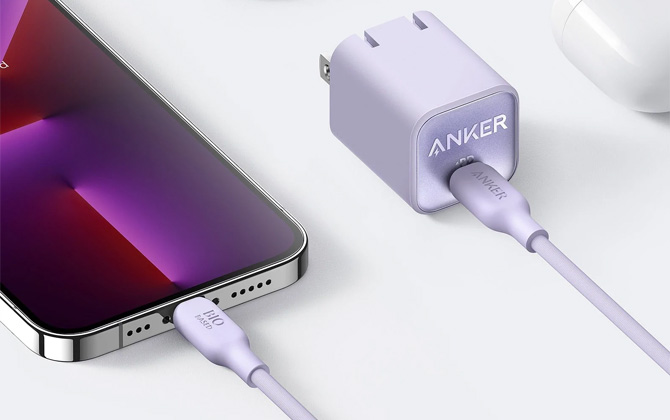 Anker 511 charge in Lilac with power prongs extended with a Lilac cable plugged into a phone.