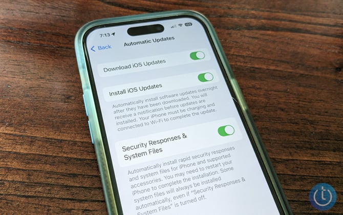 iPhone 14 Pro showing the Automatic Update Settings screen with Download iOS Updates, Install iOS Updates, and Security Responses & System Files toggled on. 