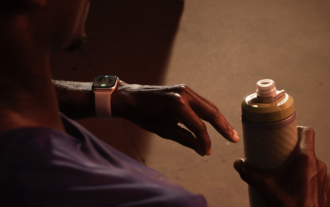 Apple Watch 9 on the wrist of a person performing a double-tap gesture.