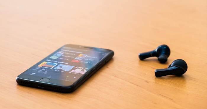 Smarphone and Bluetooth earbuds on a table