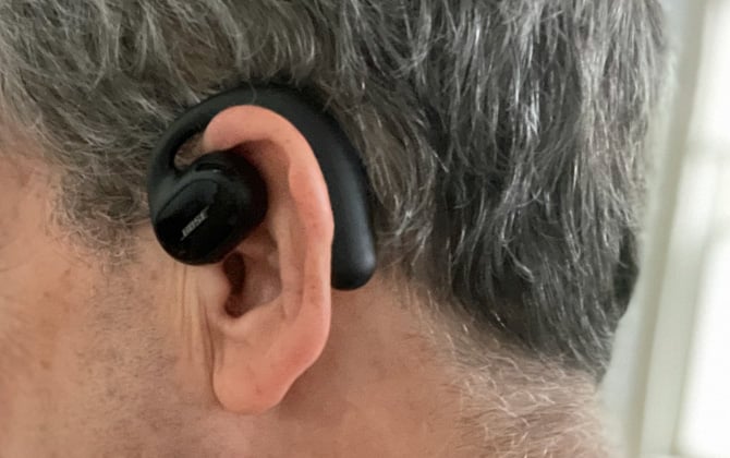 Bose Sport Open Earbud worn on model. Seen here in closeup on ear.