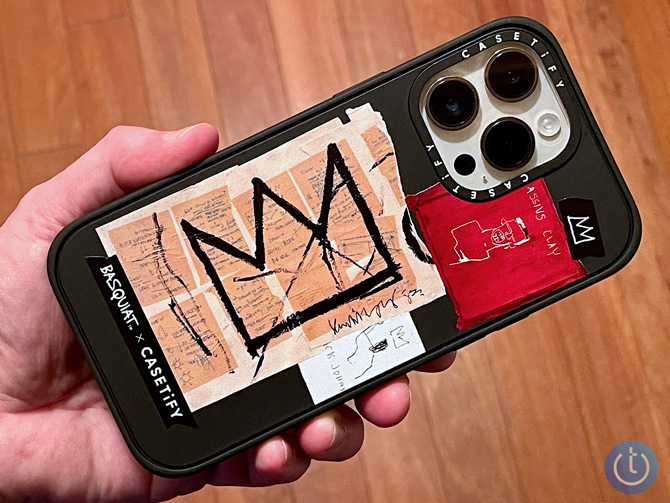 Casetify Crown Sticker case shown in hand with the Basquiat name on the case and a line drawing of a crown with a white line drawing of a person with their mouth open. 