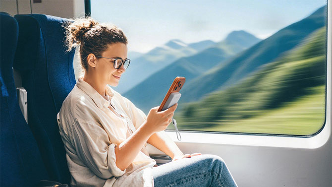 A woman holds an iPhone 17 Pro model with the EcoFlow Rapid Mag Qi2.2 power bank attached