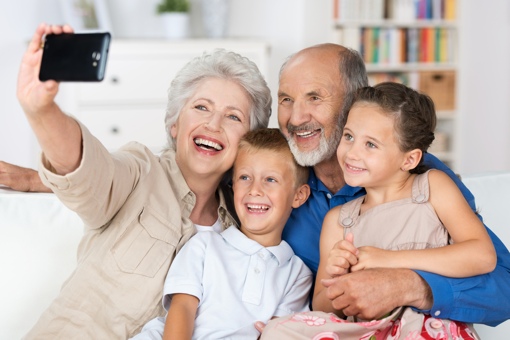 Grandparents taking smartphone selfie with grandkids