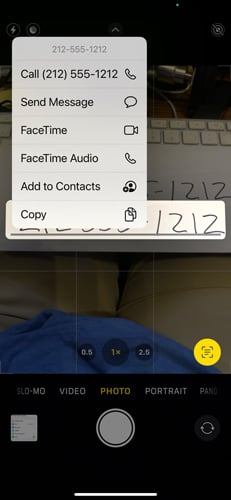 Screenshot of Camera app with scrap of paper with a phone number hand written on it. There's also a pop up menu with the option to call the number, send a message, FaceTime, FaceTime Audio, Add to Contacts, or Copy 