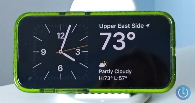 iPhone 14 Pro showing StandBy Model with the Clock and Weather widgets.