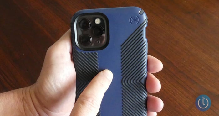 Hand holding an iPhone with a blue case with a finger tapping the back.