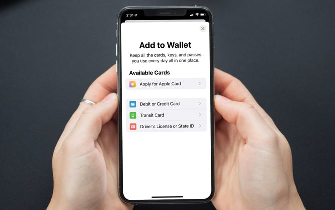 Hands holding iPhone with screenshot showing the first step of adding a driver's license to iPhone and Apple Watch. 