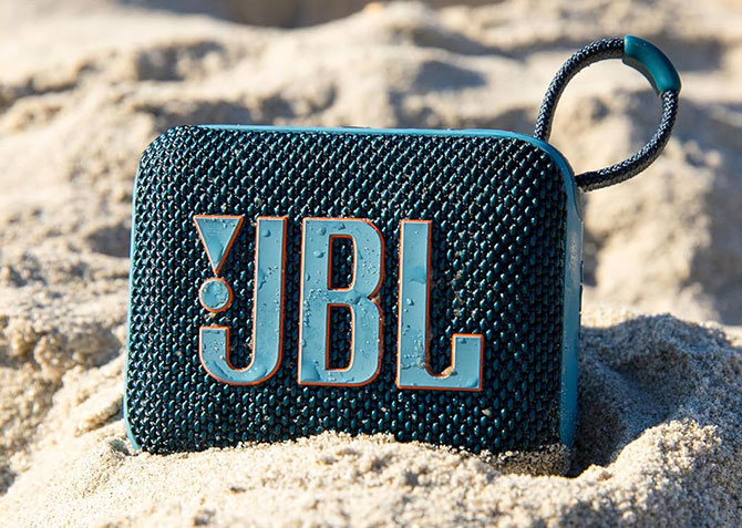 The JBL Go 4 sits in sand